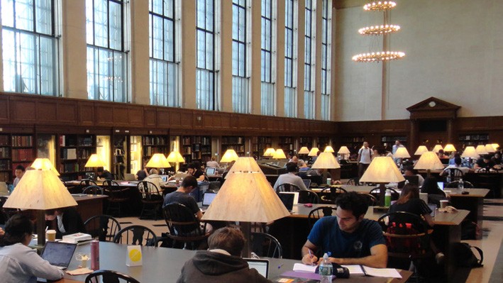 Students study and work at tables inside of Columbia University's Butler Library