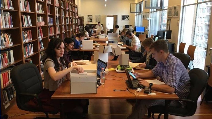Cold War Archival Research Fellows read through archived files in a library
