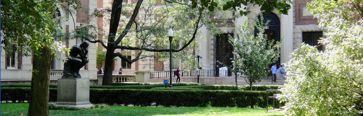 Rodin's The Thinker statue amidst greenery on Columbia University's campus