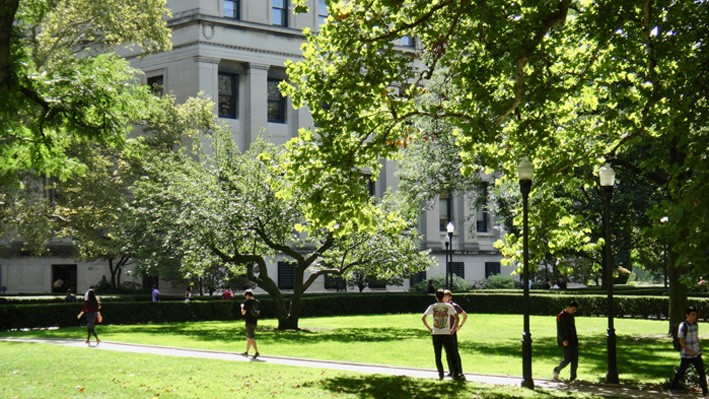 Students walk through the green lawns of Columbia University campus.