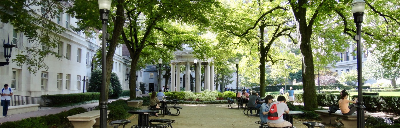 Students relax at tables on Hamilton Lawn of the Columbia University campus