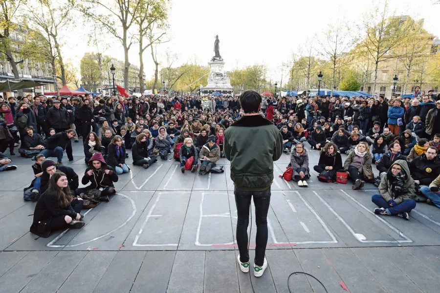 Screenshot of the film The Assembly (L'assemblee), with a boy surrounded by the crowd