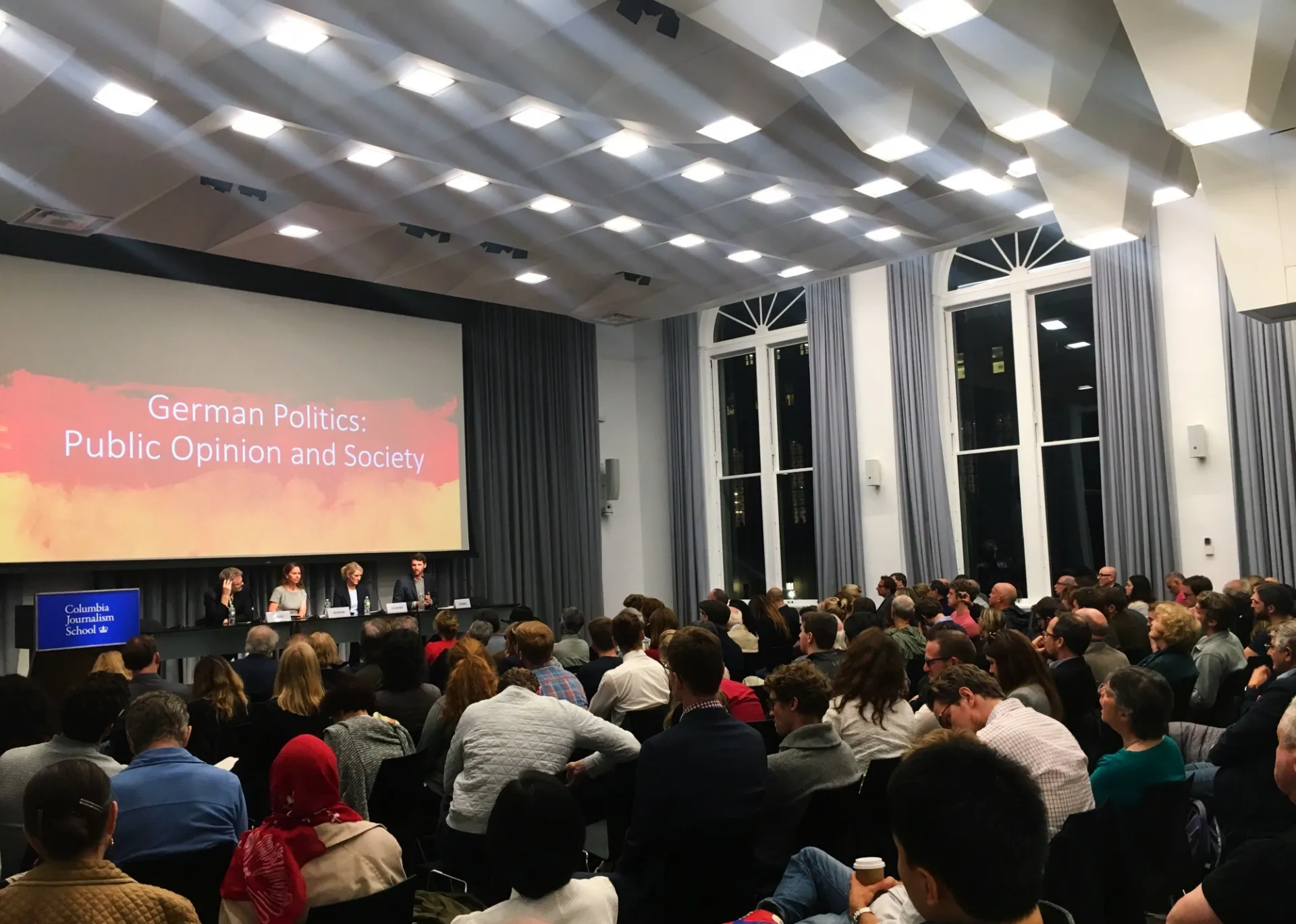 Panelists on stage discuss German elections results and implications, with an attentive audience at Columbia University.